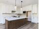 Modern kitchen with a center island, white cabinets, and stainless steel appliances at 6060 Scalybark Rd, Durham, NC 27712