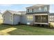 Back exterior of a two-story home with gray siding, visible porch, and green lawn at 6060 Scalybark Rd, Durham, NC 27712