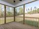 Enjoy wooded views from this screened porch with wooden beams, floors, and a ceiling fan at 6060 Scalybark Rd, Durham, NC 27712