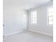 Spacious bedroom with neutral carpeting and two large windows at 6063 Scalybark Road, Durham, NC 27712