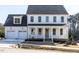 Two-story white house with gray roof, dormers, and two-car garage at 6063 Scalybark Road, Durham, NC 27712