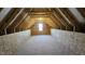 Unfinished attic space provides ample storage and expansion potential with exposed beams and a small window at 234 Crystal Springs Way, Benson, NC 27504