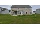 The back of the home features large windows, neutral siding, and an open yard space perfect for recreation at 234 Crystal Springs Way, Benson, NC 27504