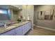 Bathroom with granite countertops, double sinks, a window, shower, and framed art on the tan walls at 234 Crystal Springs Way, Benson, NC 27504