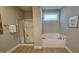 Bathroom with shower, tub, window with divided lites, and neutral walls and flooring at 234 Crystal Springs Way, Benson, NC 27504