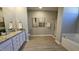 Bathroom with a double sink vanity, granite countertops, a walk-in shower, a tub, and tile floors at 234 Crystal Springs Way, Benson, NC 27504