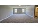 A bonus room with neutral carpet and paint, white baseboard trim, and windows on the wall at 234 Crystal Springs Way, Benson, NC 27504
