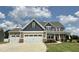 Charming two-story home with a three-car garage and front porch with stone accents at 234 Crystal Springs Way, Benson, NC 27504