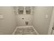 Practical laundry room includes tile flooring, overhead shelving, and convenient utility connections at 234 Crystal Springs Way, Benson, NC 27504