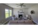 Cozy living room with a fireplace, ceiling fan, large windows, and stylish neutral decor at 234 Crystal Springs Way, Benson, NC 27504