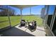 Relax on the screened porch with scenic backyard views, furnished with comfortable seating and a side table at 234 Crystal Springs Way, Benson, NC 27504