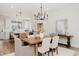 Elegant dining area with wood table and modern chandelier next to open-concept kitchen and island seating at 30 Imperial Oaks Ct, Youngsville, NC 27596