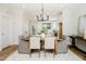 Dining room with modern chandelier and table set for six with view to the kitchen at 30 Imperial Oaks Ct, Youngsville, NC 27596