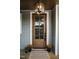 Inviting front door with glass panels, complemented by potted flowers, exudes curb appeal at 30 Imperial Oaks Ct, Youngsville, NC 27596
