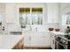 Bright kitchen with white cabinets, stainless steel appliances, and a view of the backyard through a large window at 30 Imperial Oaks Ct, Youngsville, NC 27596