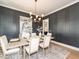 Elegant dining room with designer lighting, wainscoting, and a stylish table setting at 122 W Beech Slope Ct, Chapel Hill, NC 27517