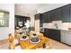 Open kitchen with black cabinets, modern appliances, dining table, and open to living room at 122 W Beech Slope Ct, Chapel Hill, NC 27517