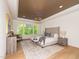 Bedroom with wood ceiling, chandelier, large windows with wooded views, and neutral decor at 122 W Beech Slope Ct, Chapel Hill, NC 27517