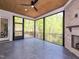 Screened porch with stone fireplace, tile flooring, ceiling fan, and wooded backyard view at 122 W Beech Slope Ct, Chapel Hill, NC 27517
