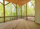 Covered porch with wooden floor and railings overlooking the wooded backyard at 122 W Beech Slope Ct, Chapel Hill, NC 27517