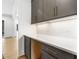 Close up on a white countertop with gray cabinets, gold pulls, backsplash, and a view to the backyard at 43 Laurel Knoll Dr, Pittsboro, NC 27312