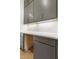 Close up on a white countertop with gray cabinets, gold pulls, backsplash, and under cabinet lights at 43 Laurel Knoll Dr, Pittsboro, NC 27312