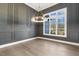 Bright dining room with gray walls, modern chandelier, beautiful hardwood floors, and a large window at 43 Laurel Knoll Dr, Pittsboro, NC 27312