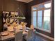 Elegant dining room with dark walls, modern decor, and abundant natural light from a large window at 43 Laurel Knoll Dr, Pittsboro, NC 27312