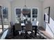 Cozy dining room with black table set, patterned rug, and natural light from large windows at 43 Laurel Knoll Dr, Pittsboro, NC 27312