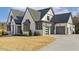 Stunning two-story home with a modern design, gray roof, white painted brick, and three-car garage at 43 Laurel Knoll Dr, Pittsboro, NC 27312