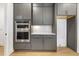 Modern kitchen with stainless steel oven and microwave, gray cabinets, and quartz countertops at 43 Laurel Knoll Dr, Pittsboro, NC 27312