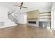 Bright living room featuring a fireplace, hardwood floors, and staircase with black iron railings at 43 Laurel Knoll Dr, Pittsboro, NC 27312