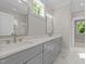 Bright bathroom featuring double vanity, quartz countertops, and large mirrors and a white marble floor at 125 Cotton Fields Ln # 26, Fuquay Varina, NC 27526