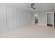Spacious bedroom with neutral carpet, a ceiling fan, wainscoting and ensuite bathroom access at 125 Cotton Fields Ln # 26, Fuquay Varina, NC 27526