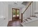 Inviting foyer with beautiful wood-look flooring, a stylish light fixture, and a staircase with white and wood accents at 125 Cotton Fields Ln # 26, Fuquay Varina, NC 27526