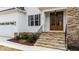 Close up of the stone steps leading to the gorgeous wood double door entry, dark shutters, and a two car garage at 125 Cotton Fields Ln # 26, Fuquay Varina, NC 27526