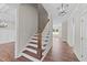 Hallway with beautiful hardwood floors and natural light, features an elegant staircase at 125 Cotton Fields Ln # 26, Fuquay Varina, NC 27526
