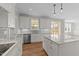 Bright kitchen features white cabinets, stainless steel appliances, island, and granite countertops at 125 Cotton Fields Ln # 26, Fuquay Varina, NC 27526