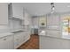 Bright, modern kitchen features white cabinets, stainless steel appliances and island with granite countertops at 125 Cotton Fields Ln # 26, Fuquay Varina, NC 27526