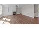 Spacious living room featuring wood floors, built-in shelving, fireplace, and easy access to other areas of the home at 125 Cotton Fields Ln # 26, Fuquay Varina, NC 27526