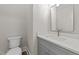 Modern powder room features gray vanity, chrome faucet, quartz countertop, and wood-style base trim at 125 Cotton Fields Ln # 26, Fuquay Varina, NC 27526