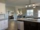 Open concept kitchen features stainless appliances, granite counters, kitchen island, and adjoins a dining room at 98 Prency Ln, Middlesex, NC 27557