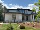 Modern home featuring light gray siding and stone accents, surrounded by fresh landscaping and a manicured lawn at 67 Quail Pt, Pittsboro, NC 27312