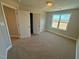 Carpeted bedroom offers neutral walls and a large window for natural light at 27 Prency Ln, Middlesex, NC 27557