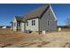 Side and rear view of the house with gray vinyl siding, dark brown roof and crawl space access at 27 Prency Ln, Middlesex, NC 27557
