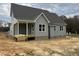 View of the house with gray vinyl siding, dark brown roof, and wooden porch being built at 27 Prency Ln, Middlesex, NC 27557