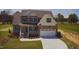 Charming two-story home with gray siding, stone accents, covered porch and white two-car garage at 27 Prency Ln, Middlesex, NC 27557