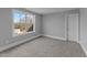 This bedroom has gray walls, plush gray carpet, white trim, a window, and a white door at 262 Hook Dr # 12, Fuquay Varina, NC 27526