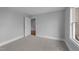 This bedroom features neutral walls and carpeting, with a large window and a door to another room at 262 Hook Dr # 12, Fuquay Varina, NC 27526