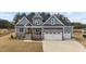 Beautiful two-story home featuring a gray exterior, stone accents, and a three-car garage at 262 Hook Dr # 12, Fuquay Varina, NC 27526